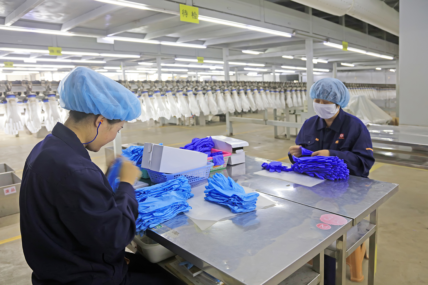 Workers assemble boxes of disposable gloves at a factory in China.