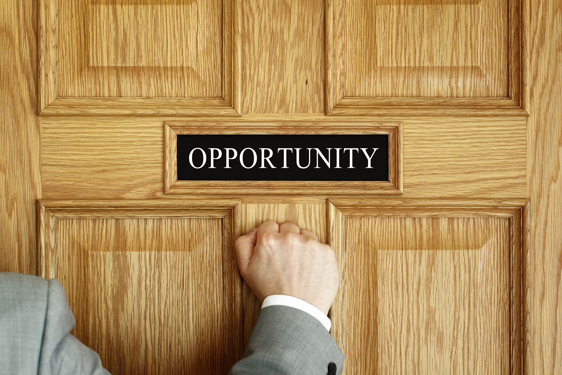 A hand knocks on a door that is labeled "OPPORTUNITY."