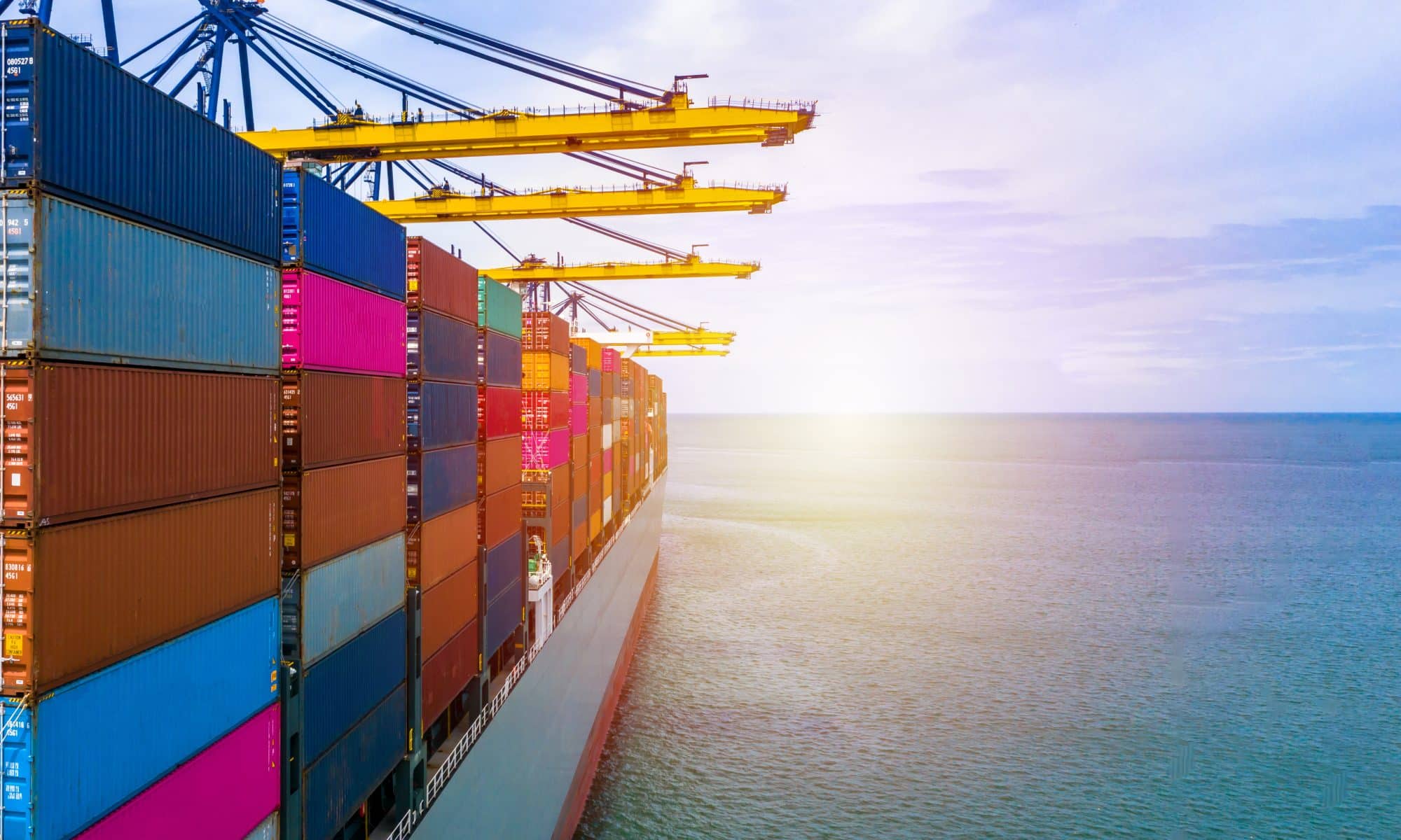 A container ship sails into the sunset.